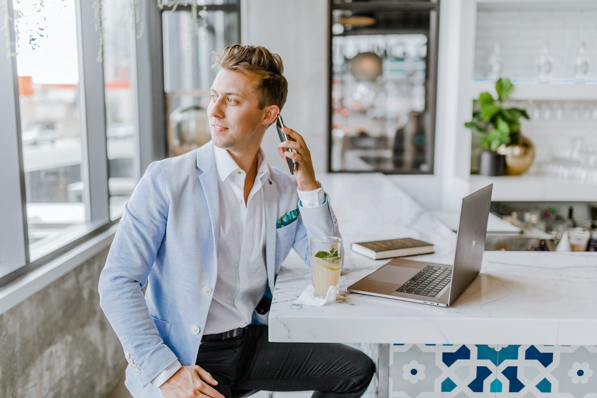 A letting agent taking a call at his desk with a laptop open